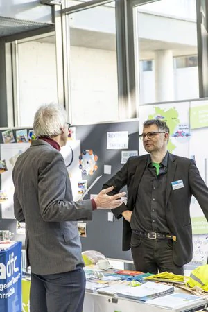 Thüringer Mobilitätskonferenz Sachlicher Austausch von zwei männlichen Personen am Messestand