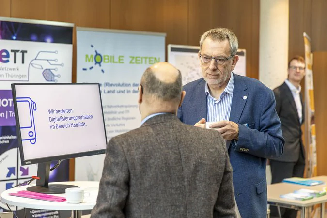 Thüringer Mobilitätskonferenz Sachlicher Austausch von zwei männlichen Personen am Messestand