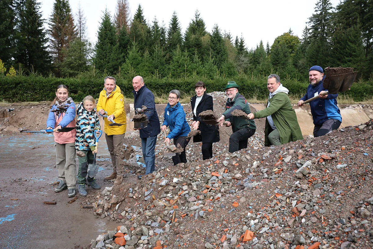 Minister Tiefensee, Familie Weidner und weitere Beteiligte beim offiziellen Spatenstich für das Naturcamp Weidner in Frauenwald..