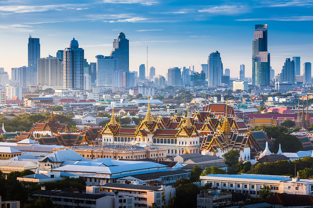 Bild: tawanlubfah / istockphoto.com Sonnenaufgang über der Skyline von Bangkok, Thailand, mit dem großen Palast im Vordergrund